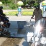 Cleaning the bikes after riding down a muddy road to the airboat ride.